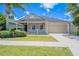 Charming single-story home with a covered front porch, landscaped yard, and a two-car garage at 316 Red Kite Dr, Groveland, FL 34736