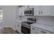 Kitchen close-up featuring white cabinets, stainless steel appliances, and quartz countertops at 316 Red Kite Dr, Groveland, FL 34736