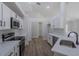 Bright kitchen with white cabinets, stainless steel appliances, and a view of the open-concept living space at 316 Red Kite Dr, Groveland, FL 34736