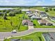 Aerial view showcasing a home with a three-car garage, lush lawn, and brick paver driveway at 3544 Lakeside Heritage Dr, Lakeland, FL 33812