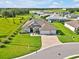 Aerial view of a charming home with a large lawn, three-car garage, and a paver driveway at 3544 Lakeside Heritage Dr, Lakeland, FL 33812
