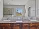Bathroom featuring a double vanity with granite countertop and large mirror at 3544 Lakeside Heritage Dr, Lakeland, FL 33812