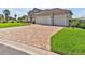 This home features a large driveway with a three-car garage and lush landscaping at 3544 Lakeside Heritage Dr, Lakeland, FL 33812