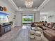 Well-lit living room features a brown sectional, decorative lighting, and sliding glass doors opening to outdoor space at 3544 Lakeside Heritage Dr, Lakeland, FL 33812