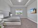 Main bedroom offers neutral color scheme, soft carpet, tray ceiling, and a large window with natural light at 3544 Lakeside Heritage Dr, Lakeland, FL 33812