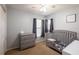 Cozy bedroom with crib, dresser, window, and ceiling fan at 4132 Festival Pointe Blvd, Mulberry, FL 33860