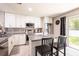 Bright kitchen with white cabinetry, granite countertops, and sliding door to the backyard at 4132 Festival Pointe Blvd, Mulberry, FL 33860