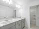 Bathroom featuring double vanity, large mirror, and a tub shower at 4732 Babys Breath Pl, Kissimmee, FL 34758