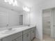 Bathroom featuring double vanity, large mirror, and a tub shower at 4732 Babys Breath Pl, Kissimmee, FL 34758
