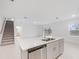 Kitchen island with stainless steel dishwasher, sink, and view into open living room at 4732 Babys Breath Pl, Kissimmee, FL 34758