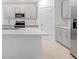 Modern kitchen featuring gray cabinets, stainless appliances, and an island with sink at 4732 Babys Breath Pl, Kissimmee, FL 34758