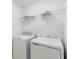 Functional laundry room featuring a side-by-side washer and dryer, with convenient overhead shelving at 4732 Babys Breath Pl, Kissimmee, FL 34758
