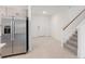 Bright living room with tile floors, white walls, and staircase, enhanced by a stainless steel refrigerator at 4732 Babys Breath Pl, Kissimmee, FL 34758