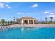 Resort-style community pool and lounge area featuring a covered cabana, perfect for relaxation and social gatherings at 4732 Babys Breath Pl, Kissimmee, FL 34758
