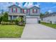 Two-story home with gray siding, red shutters, landscaped yard, and a two-car garage at 16398 Yelloweyed Dr, Clermont, FL 34714