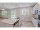 Spacious kitchen with white cabinets, large center island, and stainless steel appliances overlooking backyard at 16398 Yelloweyed Dr, Clermont, FL 34714