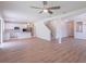 Open-concept living area with hardwood floors, white walls, and kitchen with stainless steel appliances at 16398 Yelloweyed Dr, Clermont, FL 34714