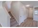 Carpeted staircase leading upstairs with hardwood flooring in the hallway and neutral walls at 16398 Yelloweyed Dr, Clermont, FL 34714
