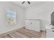 Bright bedroom featuring light wood floors, white walls, and plantation shutters for ample natural light at 2359 White Cedar Way, Haines City, FL 33844