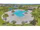 Aerial view of the community pool with palm trees, lounge chairs, and ample seating at 2359 White Cedar Way, Haines City, FL 33844