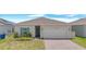 Charming single-story home featuring a two-car garage, blue shutters, and manicured landscaping at 2359 White Cedar Way, Haines City, FL 33844