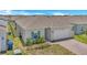 Well-maintained single-story home with a brick driveway, attached garage, and pretty landscaping at 2359 White Cedar Way, Haines City, FL 33844