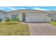 Charming single-story home with a brick driveway, two-car garage, and well-maintained landscaping at 2359 White Cedar Way, Haines City, FL 33844