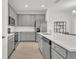 Modern kitchen with gray cabinets, stainless steel appliances, and a white quartz island at 2359 White Cedar Way, Haines City, FL 33844