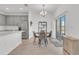 Open concept kitchen and dining area with stainless steel appliances, gray cabinets and quartz countertops; perfect for modern living at 2359 White Cedar Way, Haines City, FL 33844