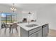 Open concept kitchen and dining area with gray cabinets, stainless steel appliances, quartz countertops, and a view to the living room at 2359 White Cedar Way, Haines City, FL 33844