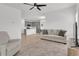 Open-concept living space with gray cabinets in kitchen and neutral living room furniture creates a bright and welcoming atmosphere at 2359 White Cedar Way, Haines City, FL 33844