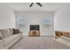 Bright living room with neutral-toned furniture, ceiling fan, and large windows with blinds offering a comfortable living space at 2359 White Cedar Way, Haines City, FL 33844
