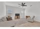 Bright living room with neutral-toned furniture, ceiling fan, and large windows with blinds, offering a comfortable living space at 2359 White Cedar Way, Haines City, FL 33844
