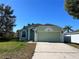 Charming, single-story home featuring a two-car garage, lush landscaping, and a welcoming front entrance, perfect for families at 103 Thornbush Pkwy, Davenport, FL 33837