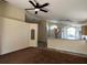 Bright living room with carpeted floors, a ceiling fan, and a view of the open kitchen at 103 Thornbush Pkwy, Davenport, FL 33837