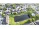 Aerial view of the community showcasing lush landscaping, a pond, a pool, and housing at 1634 Plumeria Pl, Oviedo, FL 32765