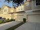 Beige two-story townhome with a two-car garage and a paved driveway at 1634 Plumeria Pl, Oviedo, FL 32765
