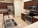Kitchen with stainless steel appliances, dark wood cabinets, and granite countertops at 1634 Plumeria Pl, Oviedo, FL 32765