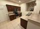 Kitchen with stainless steel appliances, dark wood cabinets, and granite countertops at 1634 Plumeria Pl, Oviedo, FL 32765