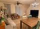 Open-concept living room with tile floors, chandelier, ceiling fan, and staircase at 1634 Plumeria Pl, Oviedo, FL 32765