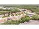 An aerial view shows a suburban neighborhood nestled among lush greenery and a tranquil pond at 16828 N Gold Star Ct, Clermont, FL 34714