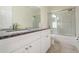 Bathroom featuring granite countertops, a framed mirror, white cabinets, and a shower with glass doors at 16828 N Gold Star Ct, Clermont, FL 34714