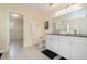 Bright bathroom features dual sinks, white cabinets, and a separate walk-in closet at 16828 N Gold Star Ct, Clermont, FL 34714