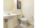 Clean bathroom featuring a pedestal sink, toilet, and neutral decor at 16828 N Gold Star Ct, Clermont, FL 34714