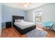 Comfortable bedroom featuring a modern bed frame, a light blue accent wall, and a window view at 16828 N Gold Star Ct, Clermont, FL 34714