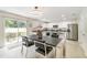 Modern dining area with stylish table, chairs, and a sliding door to the outdoor area, next to the kitchen at 16828 N Gold Star Ct, Clermont, FL 34714