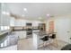 Well-lit kitchen featuring stainless steel appliances, granite countertops, and an island with bar stool seating at 16828 N Gold Star Ct, Clermont, FL 34714