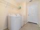 Functional laundry room featuring a washer, dryer, and storage shelving at 16828 N Gold Star Ct, Clermont, FL 34714