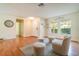 Inviting living room featuring hardwood floors, large windows, and stylish neutral furniture at 16828 N Gold Star Ct, Clermont, FL 34714