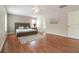 Bright main bedroom with hardwood floors, ceiling fan, and a view into the bathroom at 16828 N Gold Star Ct, Clermont, FL 34714